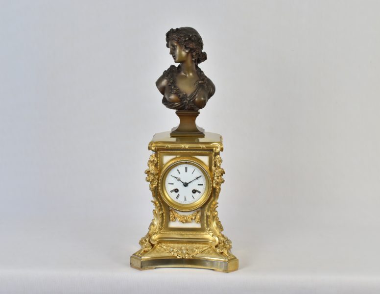 An early 19th century French gilt bronze and marble mantle clock surmounted with a bronze bust signed ‘Marin’ for Joseph-Charles Marin, French sculptor (1759-1834).