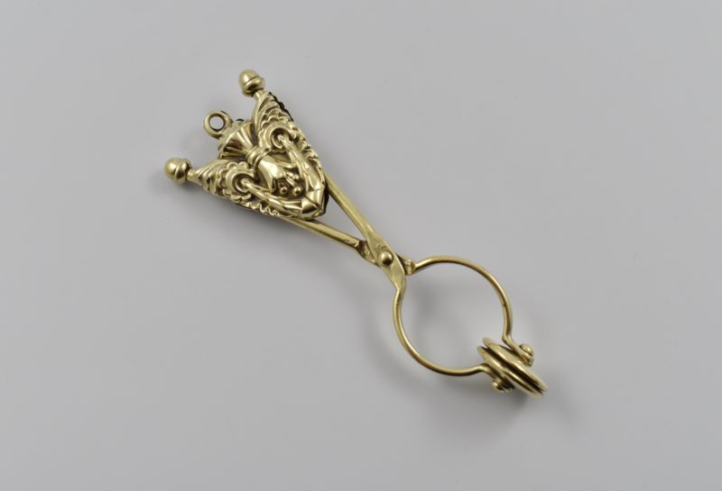 Late 19th century English brass skirt lifter – it clamps on to the hem of the dress and then attaches to the belt lifting ladies’ full-length skirts away from the ground.
