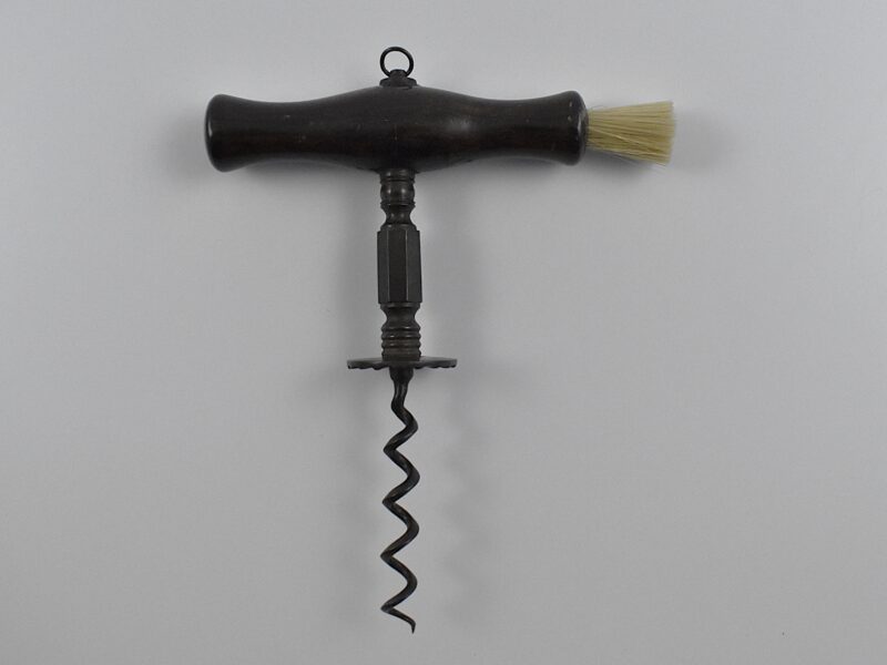 An English straight pull corkscrew with wood handle incorporating a dusting brush and hanging ring. Turned and faceted steel stem ending in a ‘Henshall button’, the underside of which is cut with fluting.