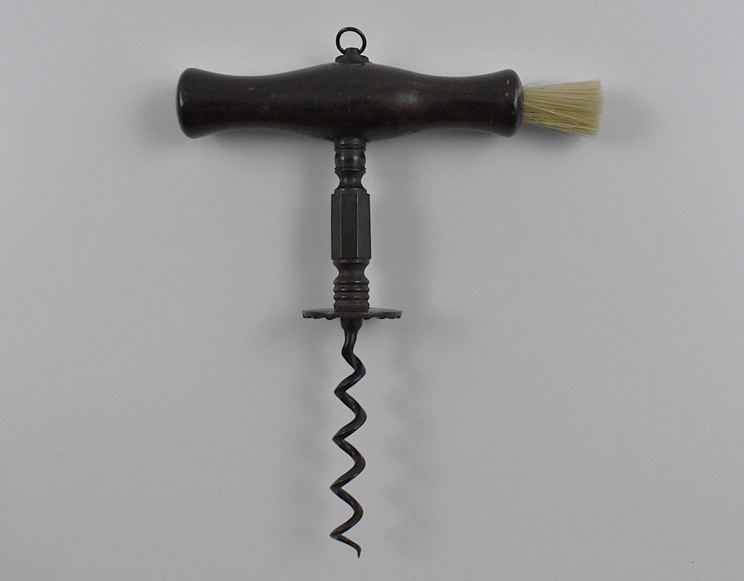 An English straight pull corkscrew with wood handle incorporating a dusting brush and hanging ring. Turned and faceted steel stem ending in a ‘Henshall button’, the underside of which is cut with fluting. - Image 2
