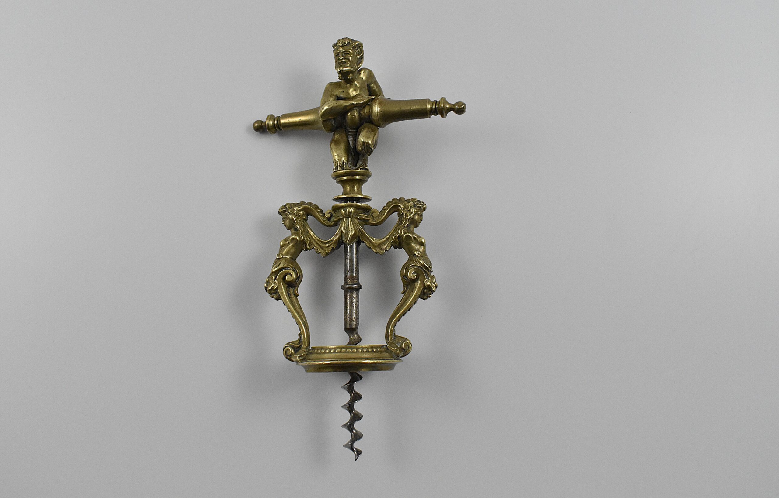 A magnificent two pillar cast brass corkscrew surmounted with a satyr embracing the handle. The two columns are caryatids and they stand on the bottle collar that allows centering of the perfect centre cut bladed worm. In Italian representations of a satyr as a man, he has a goat's ears, tail, legs and horns. This may suggest Italy as the source for this design. Circa 1860. - Image 2