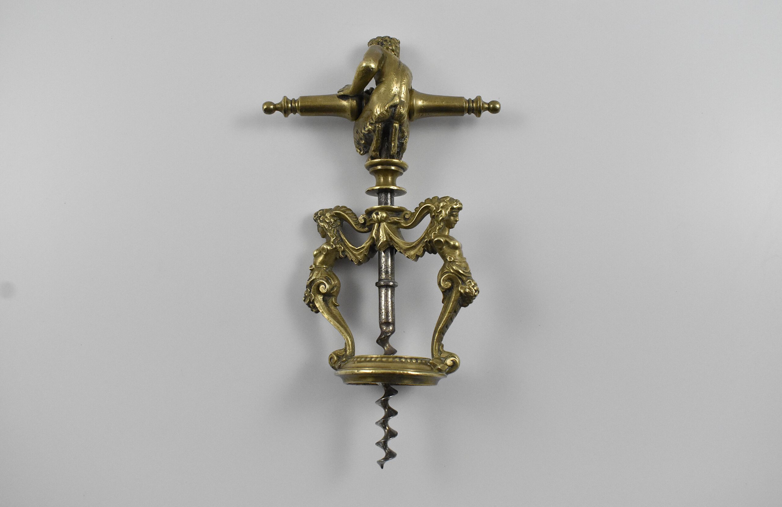 A magnificent two pillar cast brass corkscrew surmounted with a satyr embracing the handle. The two columns are caryatids and they stand on the bottle collar that allows centering of the perfect centre cut bladed worm. In Italian representations of a satyr as a man, he has a goat's ears, tail, legs and horns. This may suggest Italy as the source for this design. Circa 1860. - Image 3
