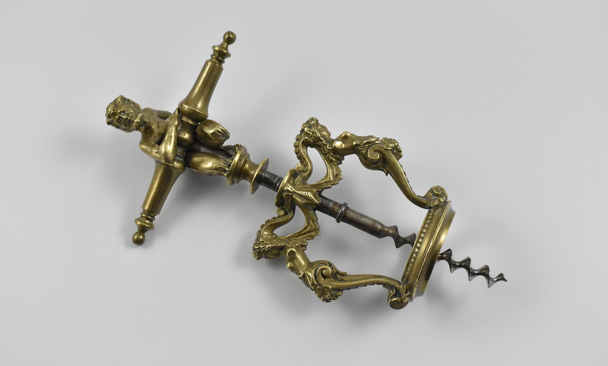 A magnificent two pillar cast brass corkscrew surmounted with a satyr embracing the handle. The two columns are caryatids and they stand on the bottle collar that allows centering of the perfect centre cut bladed worm. In Italian representations of a satyr as a man, he has a goat's ears, tail, legs and horns. This may suggest Italy as the source for this design. Circa 1860. - Image 4