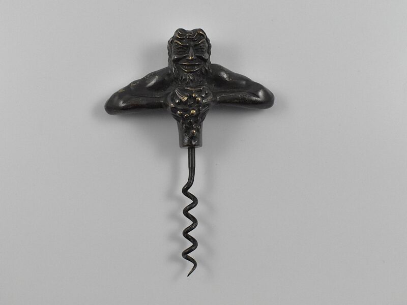 A bronze straight pull corkscrew with a representation of Bacchus squeezing a bunch of grapes.