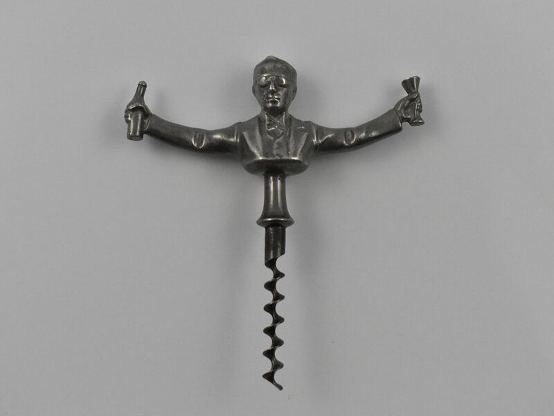 A Scandinavian straight pull cast pewter corkscrew with a representation of Ivan Bratt (1878- 1956) holding a bottle and glass in his outstretched arms. He was a Swedish politician who introduced the state – owned alcohol monopoly in 1917. He was detested for the introduction of the S. C. Bratt system which limited the purchase of no more than four litres of alcohol per month per person. This example marked “SWENSKIT TENN” (Swedish Pewter) under the back.