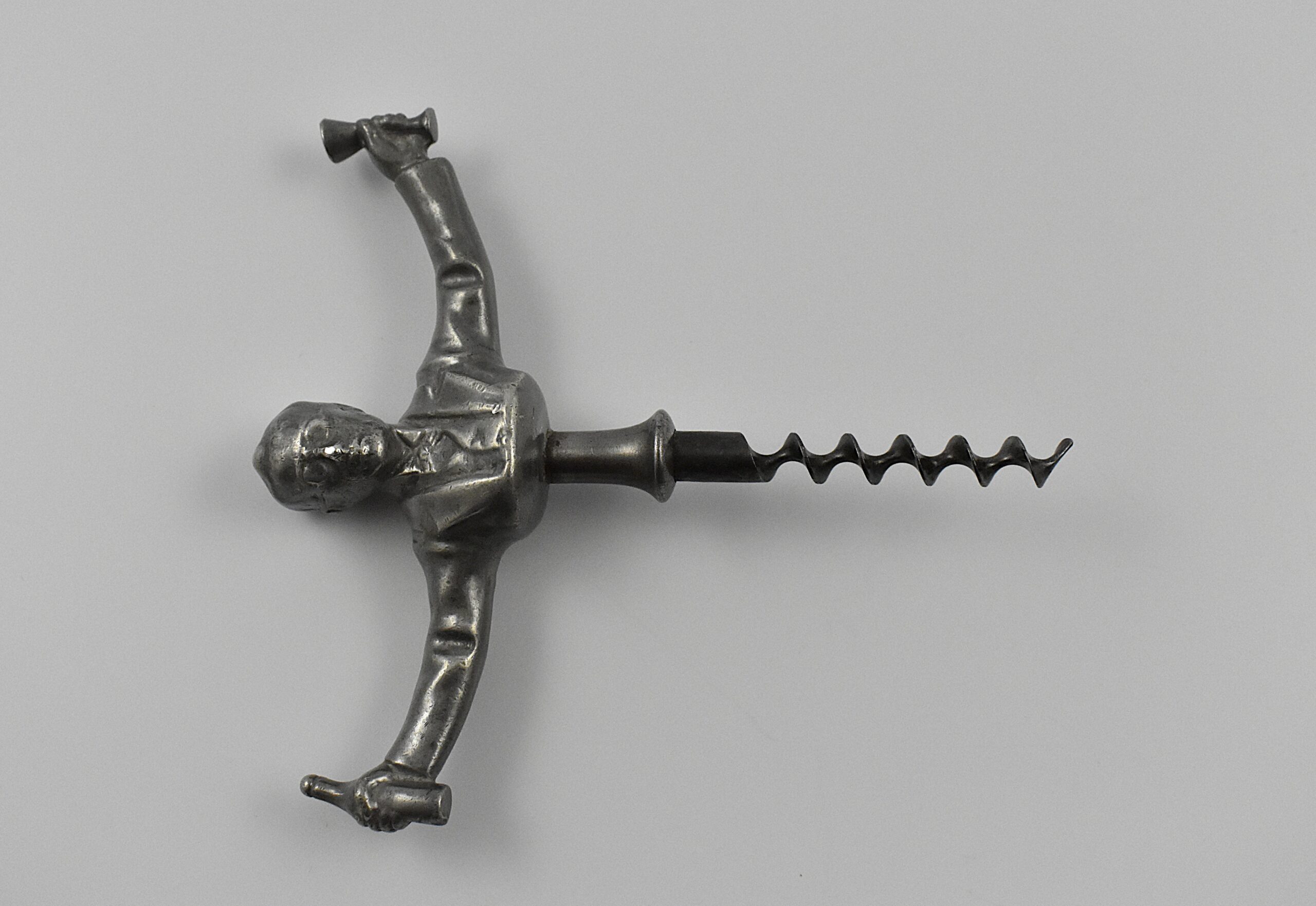 A Scandinavian straight pull cast pewter corkscrew with a representation of Ivan Bratt (1878- 1956) holding a bottle and glass in his outstretched arms. He was a Swedish politician who introduced the state – owned alcohol monopoly in 1917. He was detested for the introduction of the S. C. Bratt system which limited the purchase of no more than four litres of alcohol per month per person. This example marked “SWENSKIT TENN” (Swedish Pewter) under the back. - Image 2