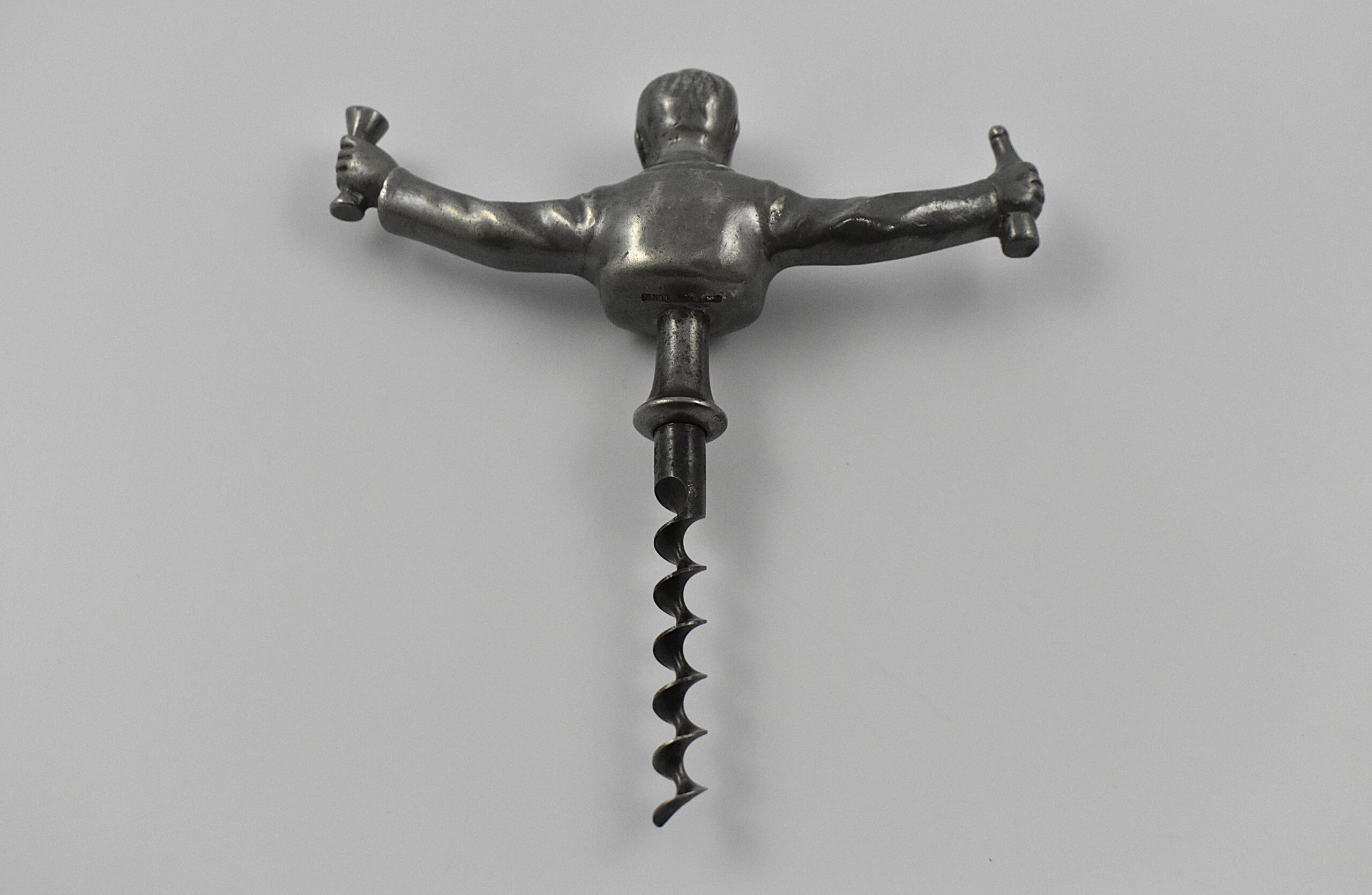 A Scandinavian straight pull cast pewter corkscrew with a representation of Ivan Bratt (1878- 1956) holding a bottle and glass in his outstretched arms. He was a Swedish politician who introduced the state – owned alcohol monopoly in 1917. He was detested for the introduction of the S. C. Bratt system which limited the purchase of no more than four litres of alcohol per month per person. This example marked “SWENSKIT TENN” (Swedish Pewter) under the back. - Image 3